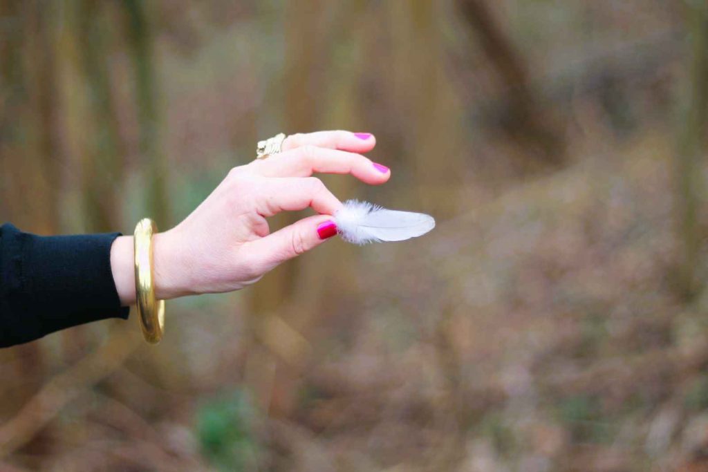 Hand with feather illustrating lightness