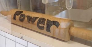 Rolling pin behind glass with the word power written on